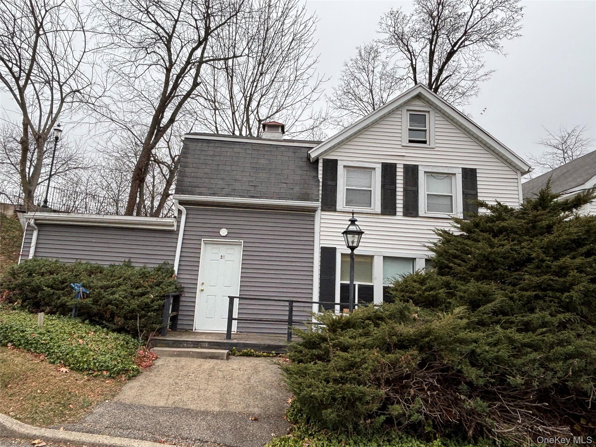View of front facade featuring a chimney and roof with shingles