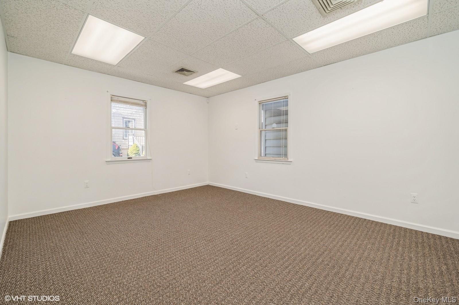 Carpeted spare room with a drop ceiling