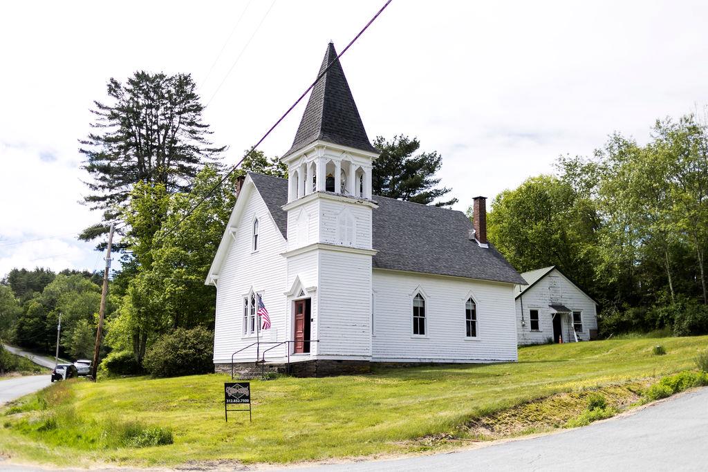 View of side of property featuring a chimney, a yard, and roof with shingles