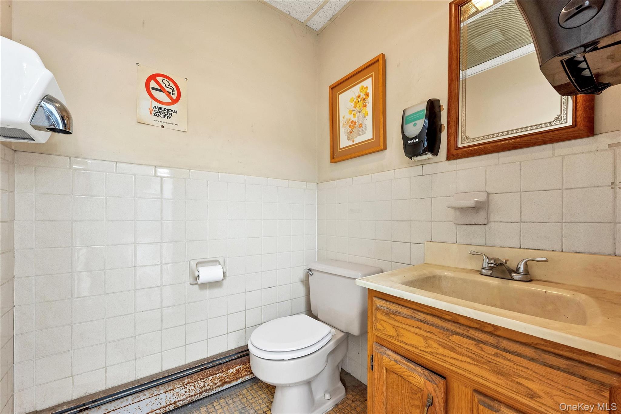 Bathroom with vanity, toilet, tile patterned flooring, and tile walls