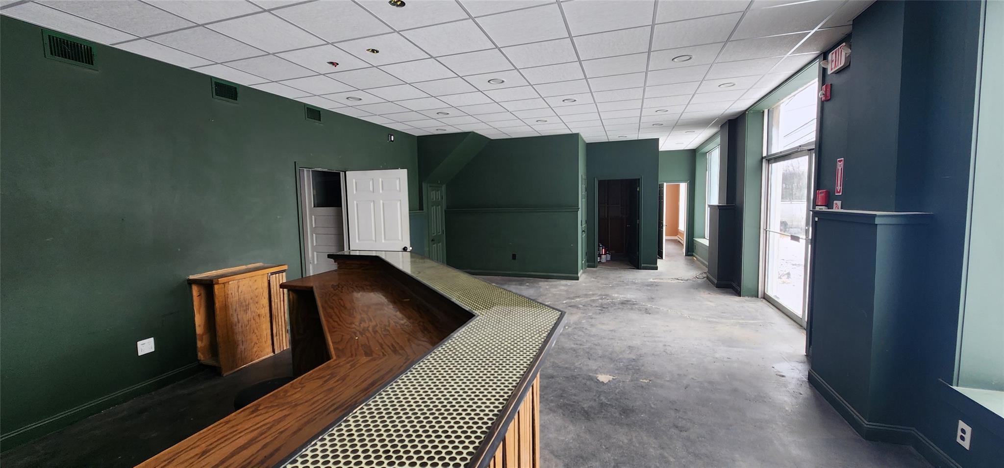 Hall with a paneled ceiling and concrete floors