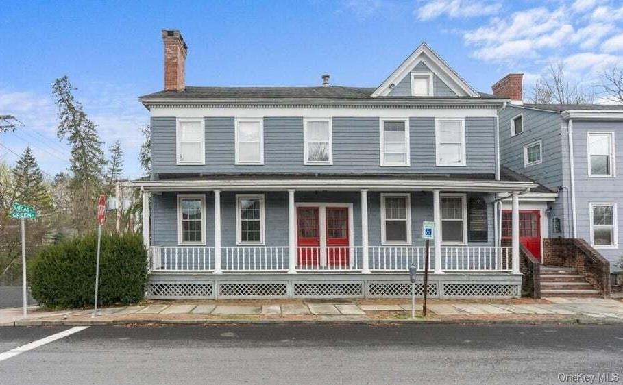 View of front facade with a porch and a chimney