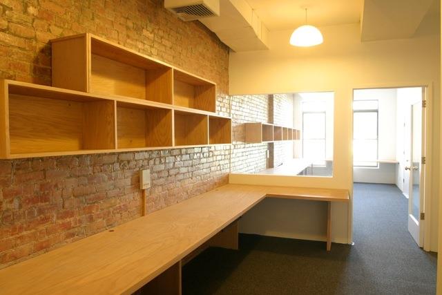 Unfurnished office space with brick wall & plenty of storage