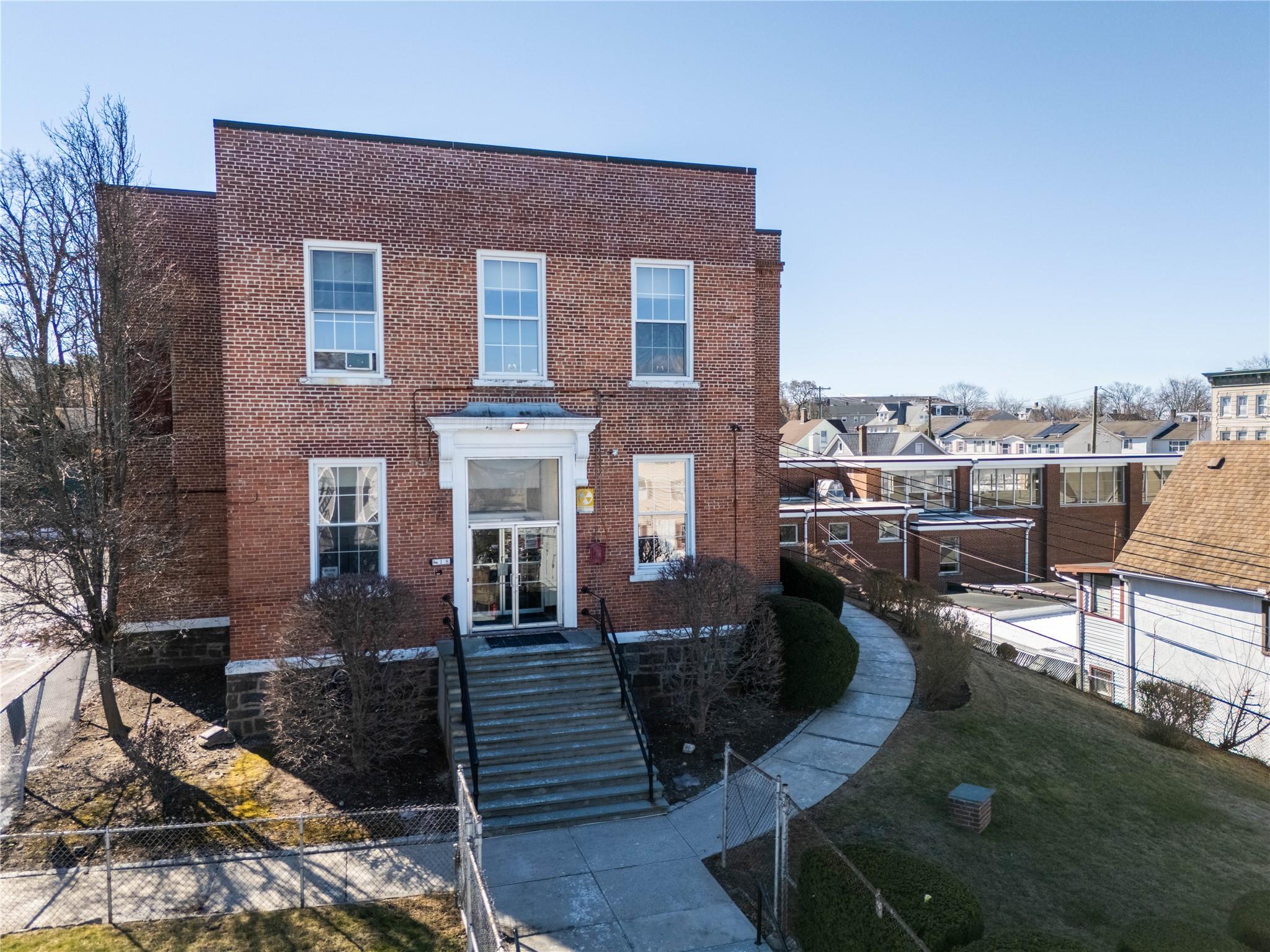 View of front facade with brick siding and fence