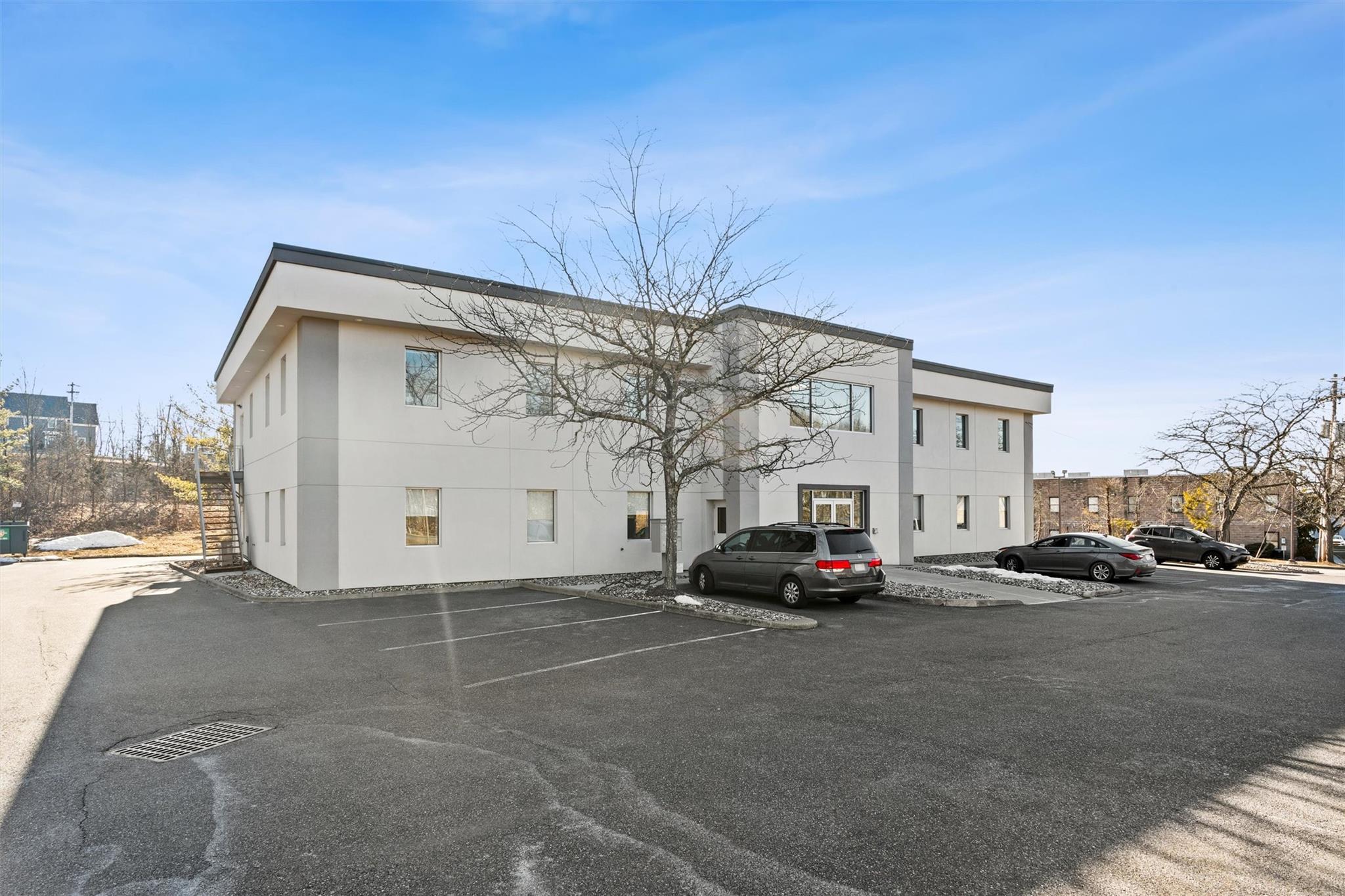 View of building exterior featuring uncovered parking