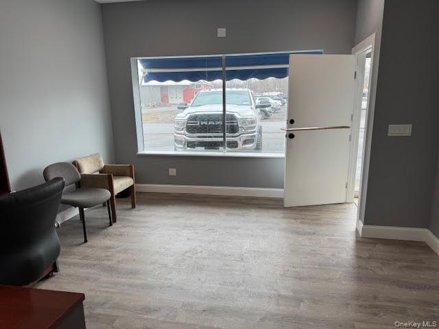 Sitting area featuring baseboards and wood finished floors