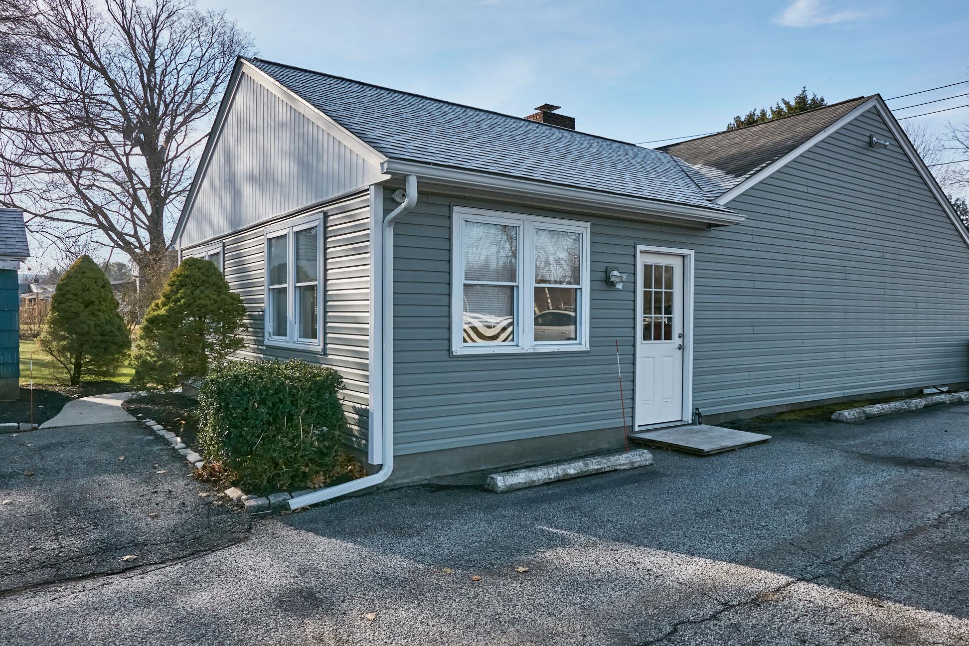 View of front of house with a shingled roof and a chimney