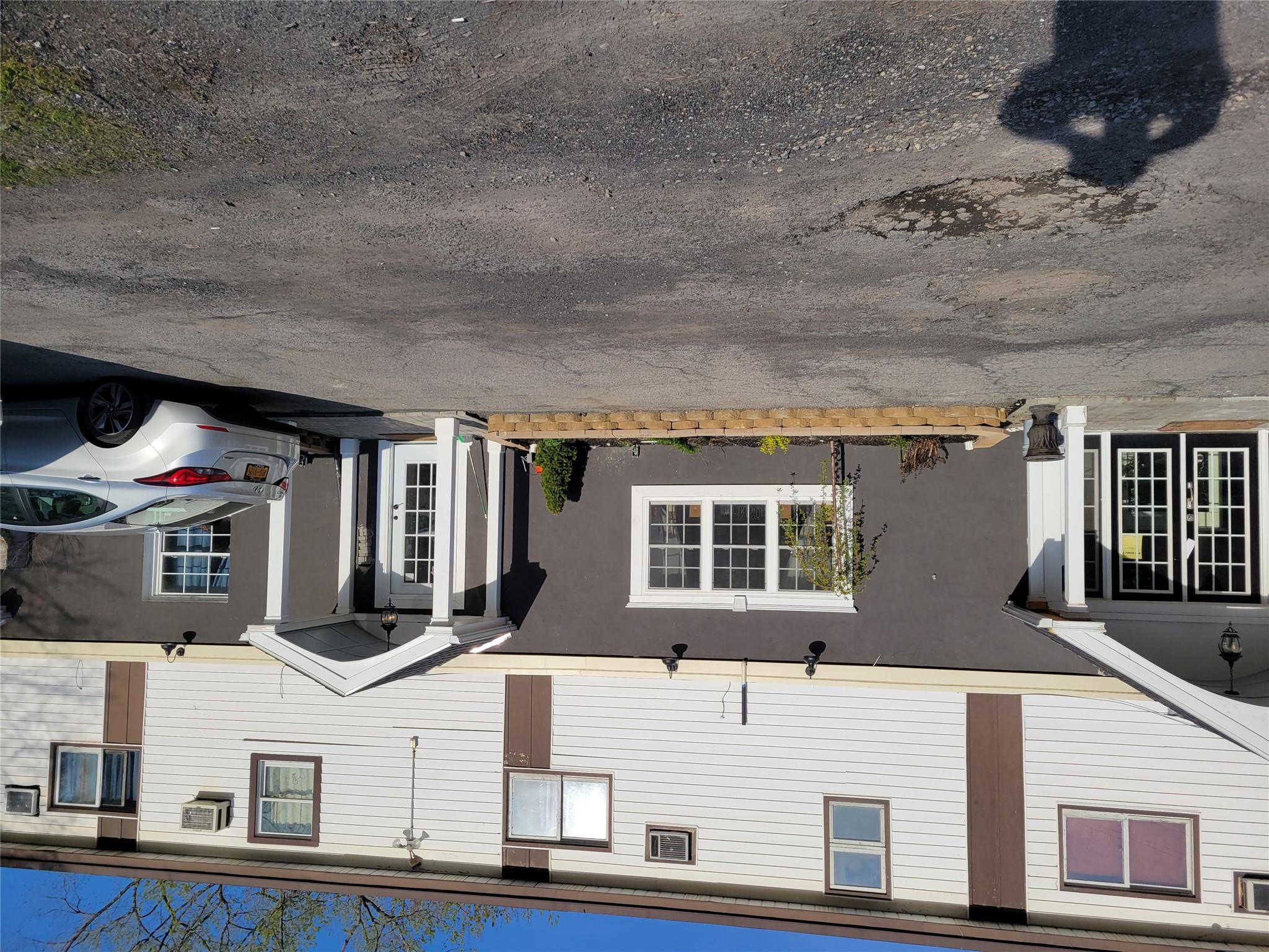 Multi-family property with stucco siding, french doors, and a wall unit AC