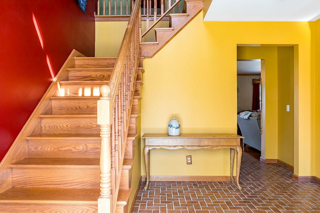 Stairs featuring brick floor and baseboards