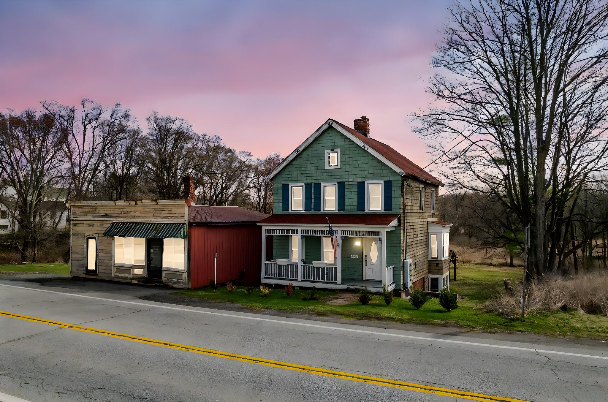 View of front facade featuring a chimney and a porch