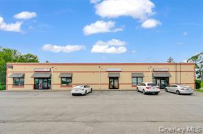 View of commercial location featuring uncovered parking