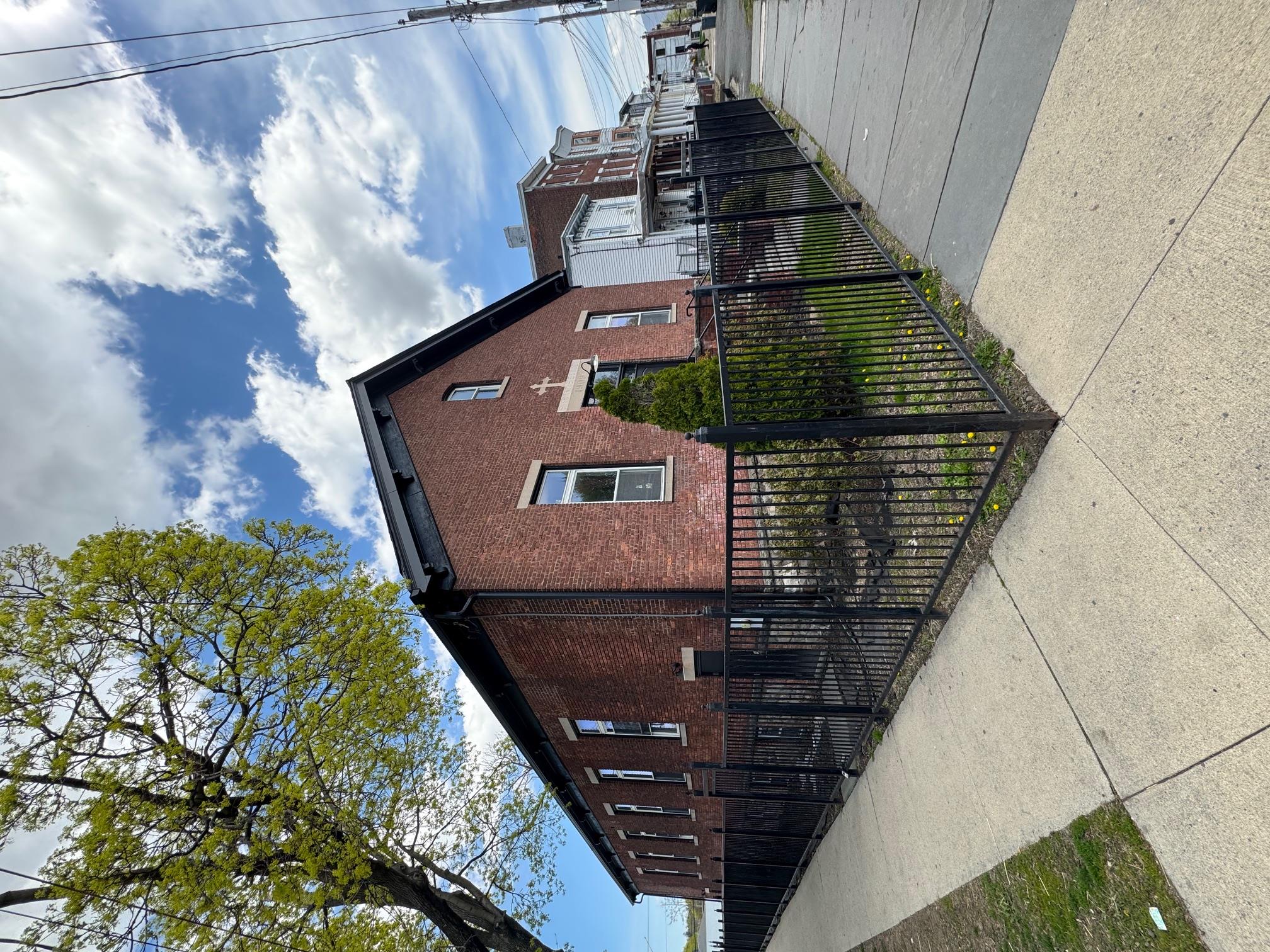 View of home's exterior with brick siding and a fenced front yard