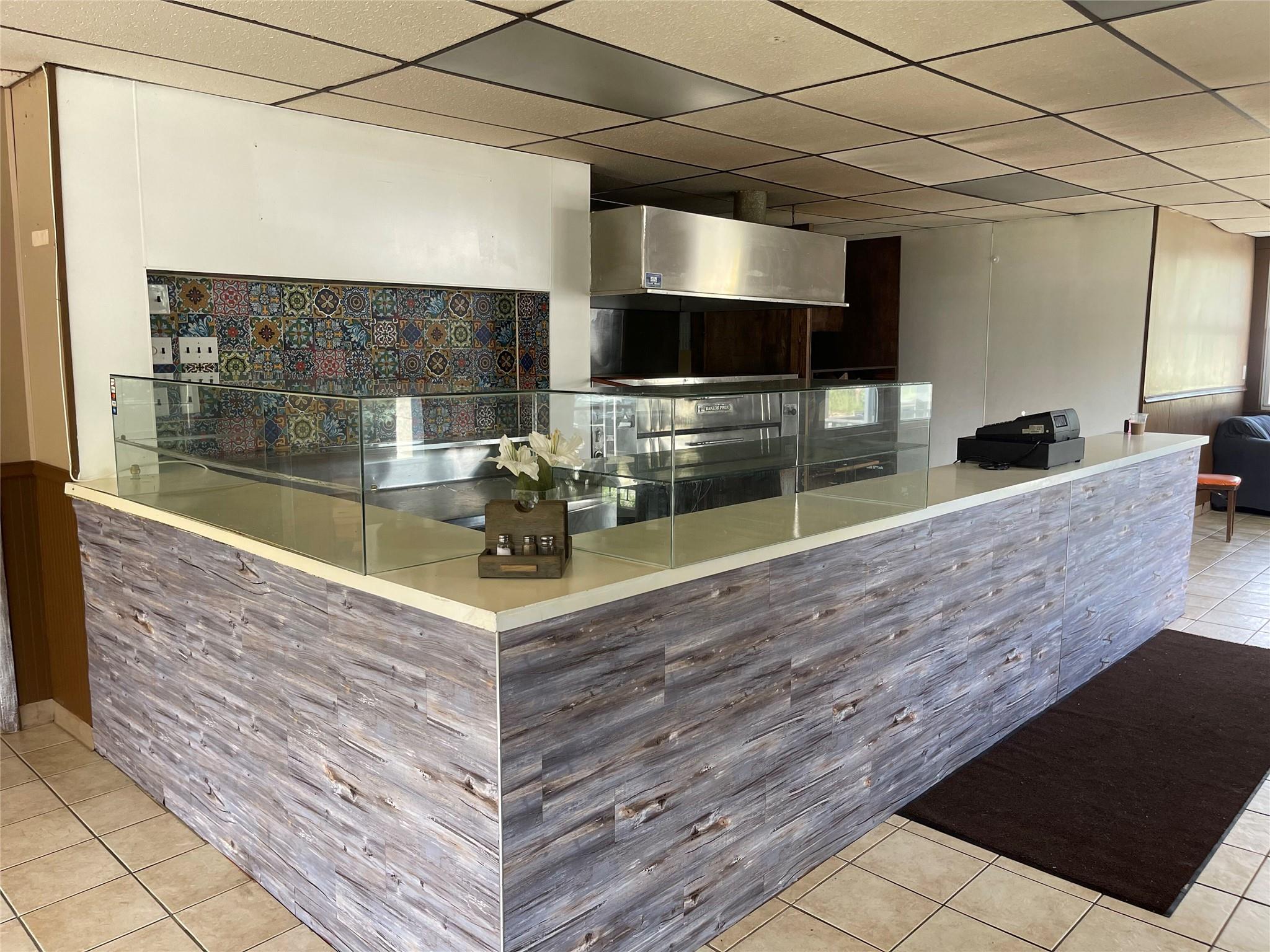 Kitchen with tile patterned floors and a drop ceiling