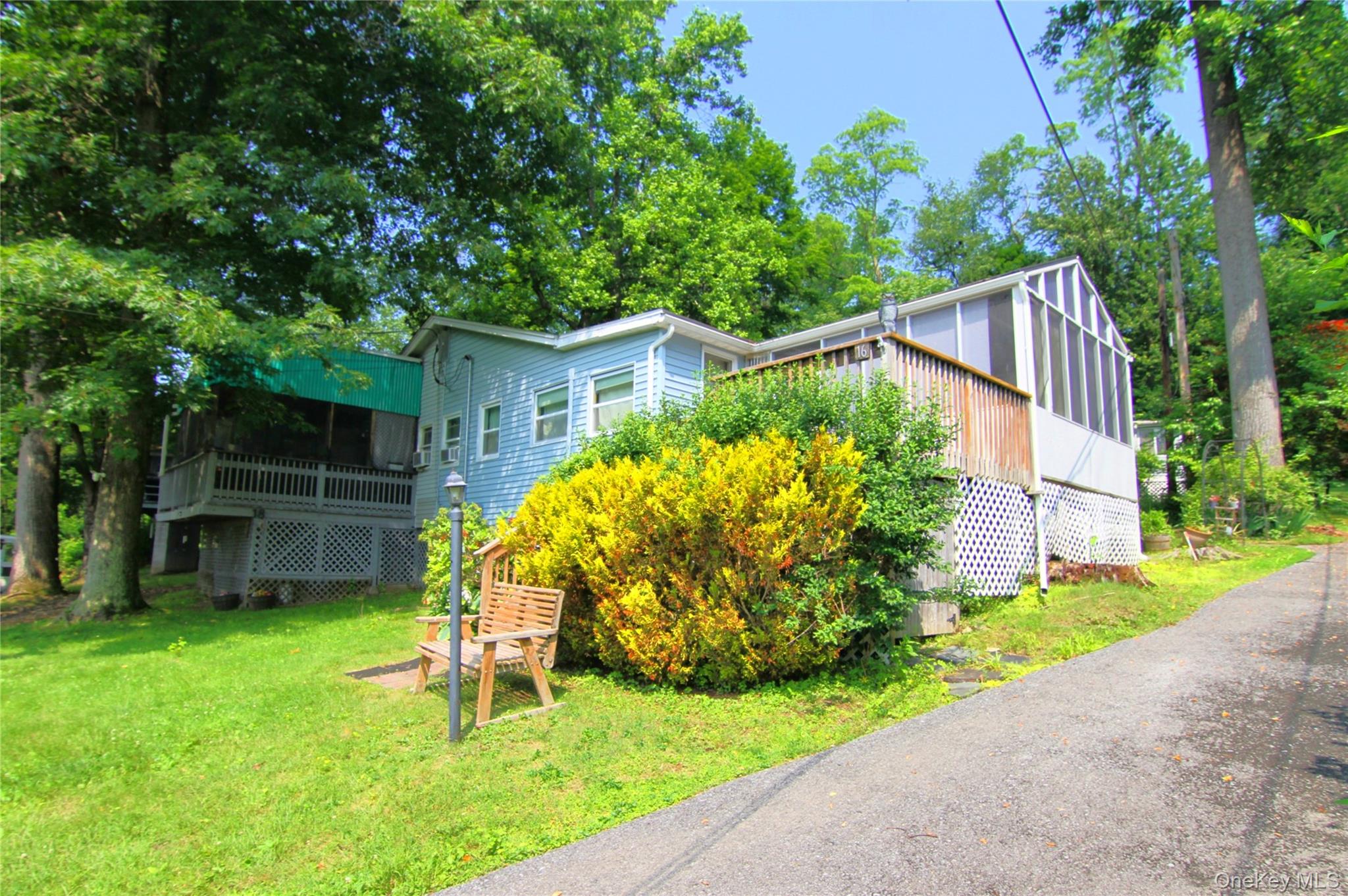 View of front facade featuring a front lawn and a deck