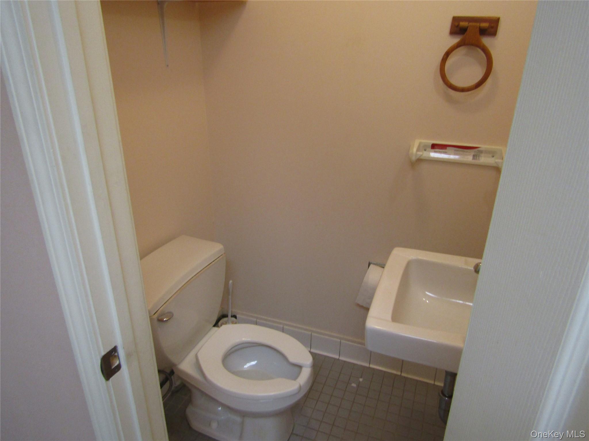 Bathroom featuring tile patterned flooring, toilet, and sink