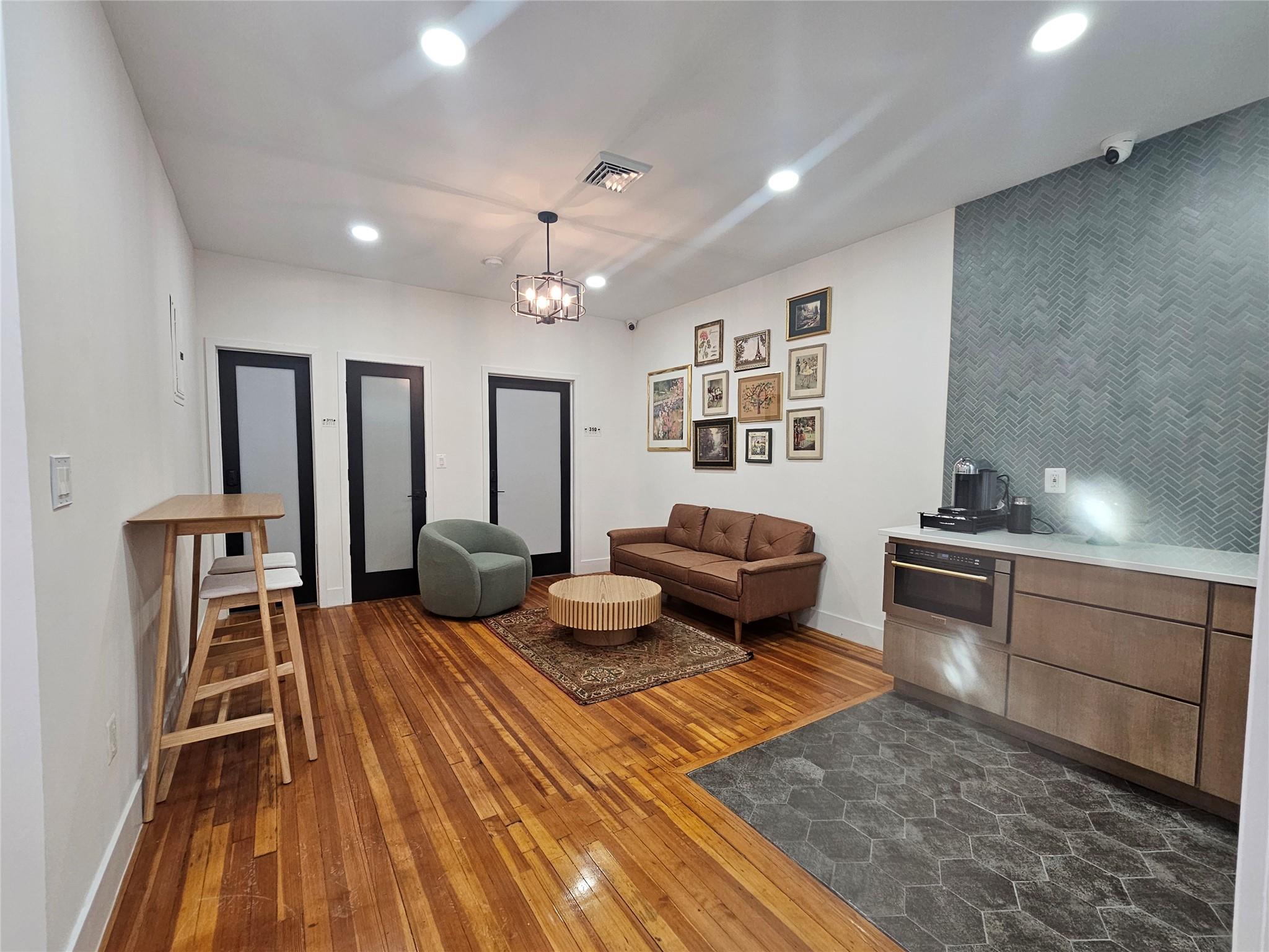 Living area with dark wood finished floors, baseboards, and recessed lighting