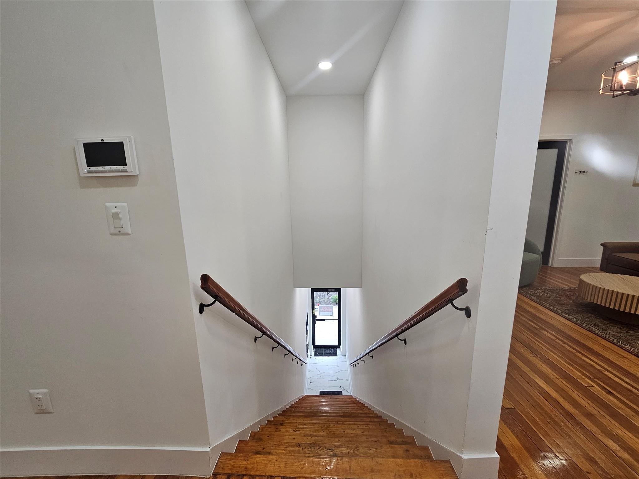 Stairway featuring wood-type flooring, recessed lighting, and baseboards