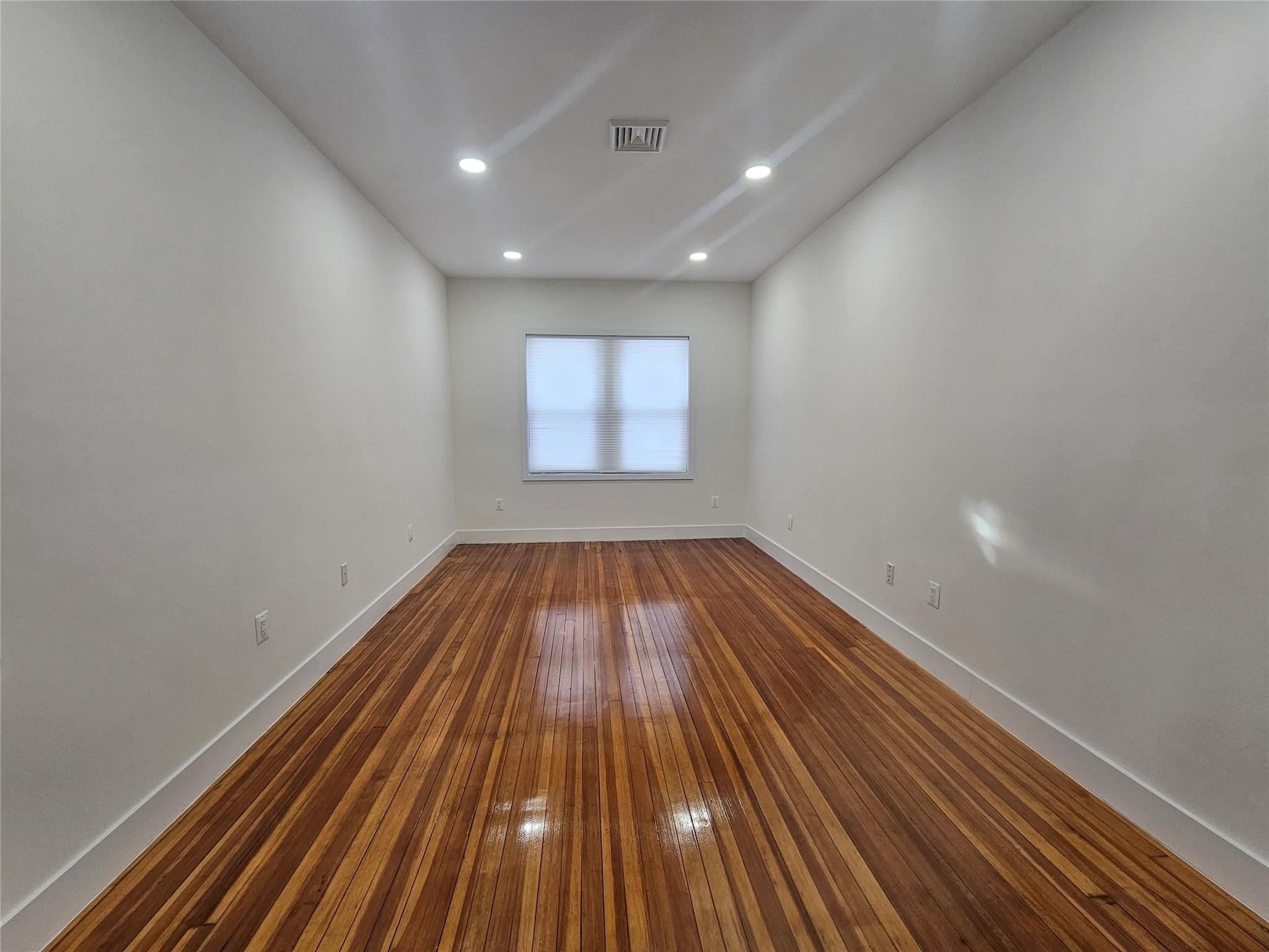 Unfurnished room featuring baseboards, dark wood-style floors, and recessed lighting