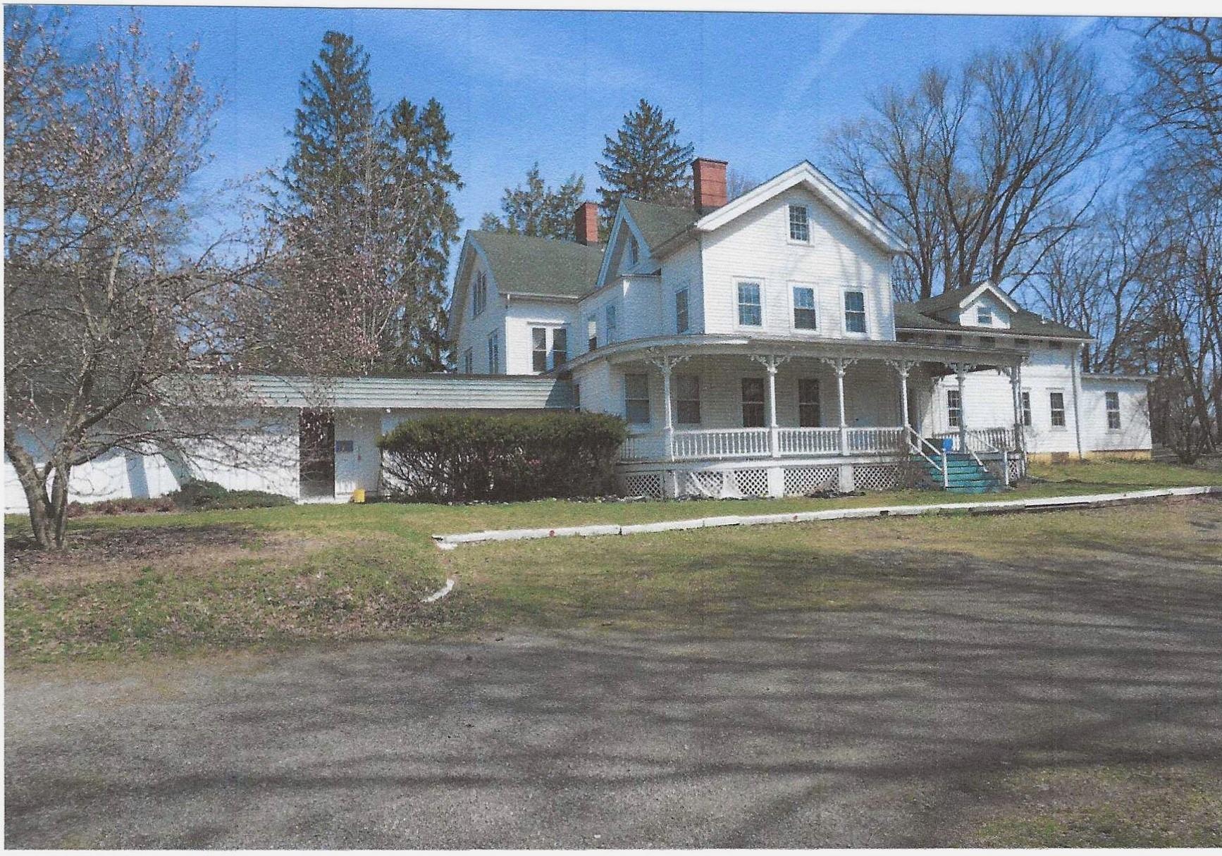 View of front of home featuring a porch and a chimney