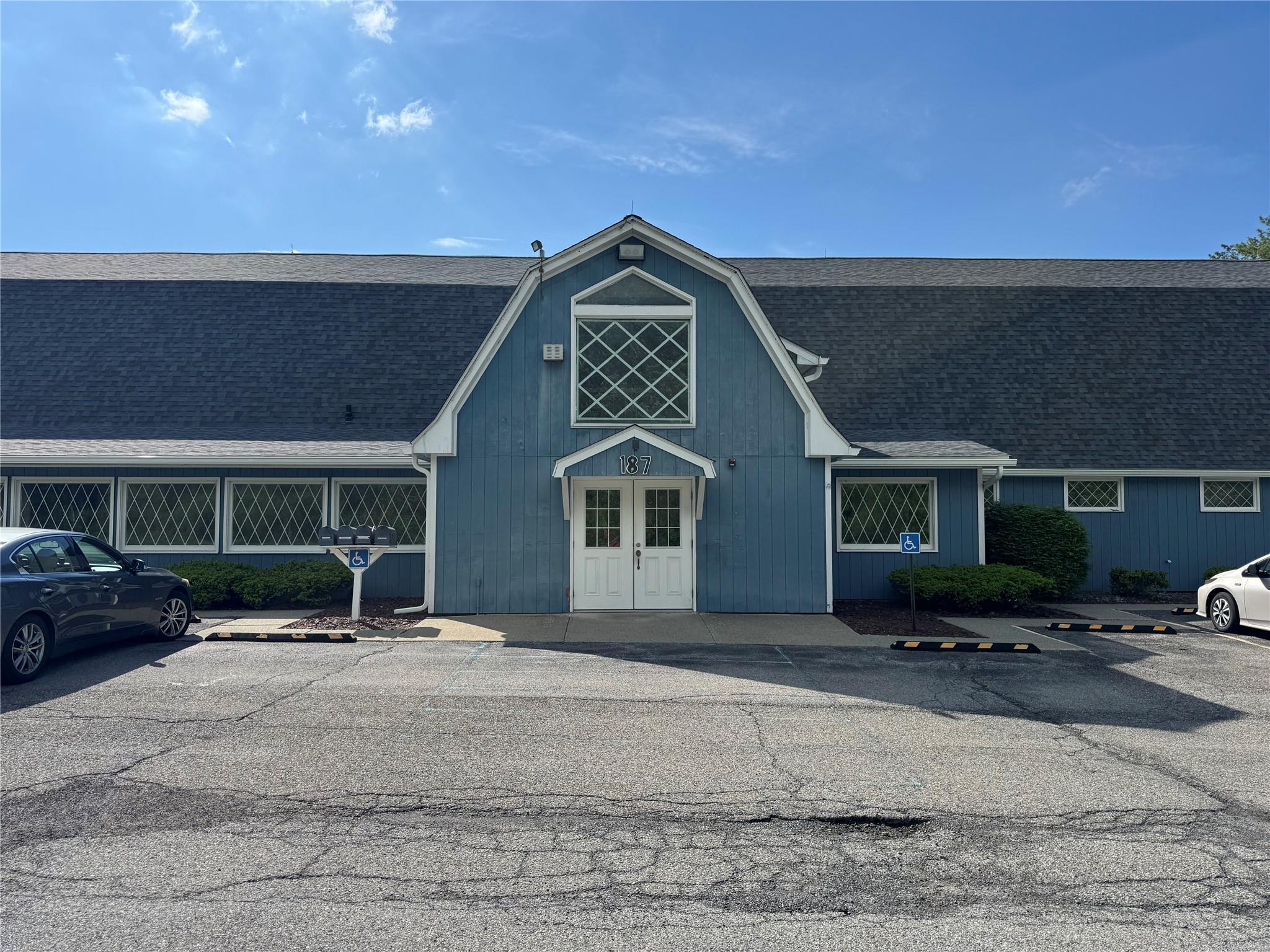 View of building exterior featuring uncovered parking