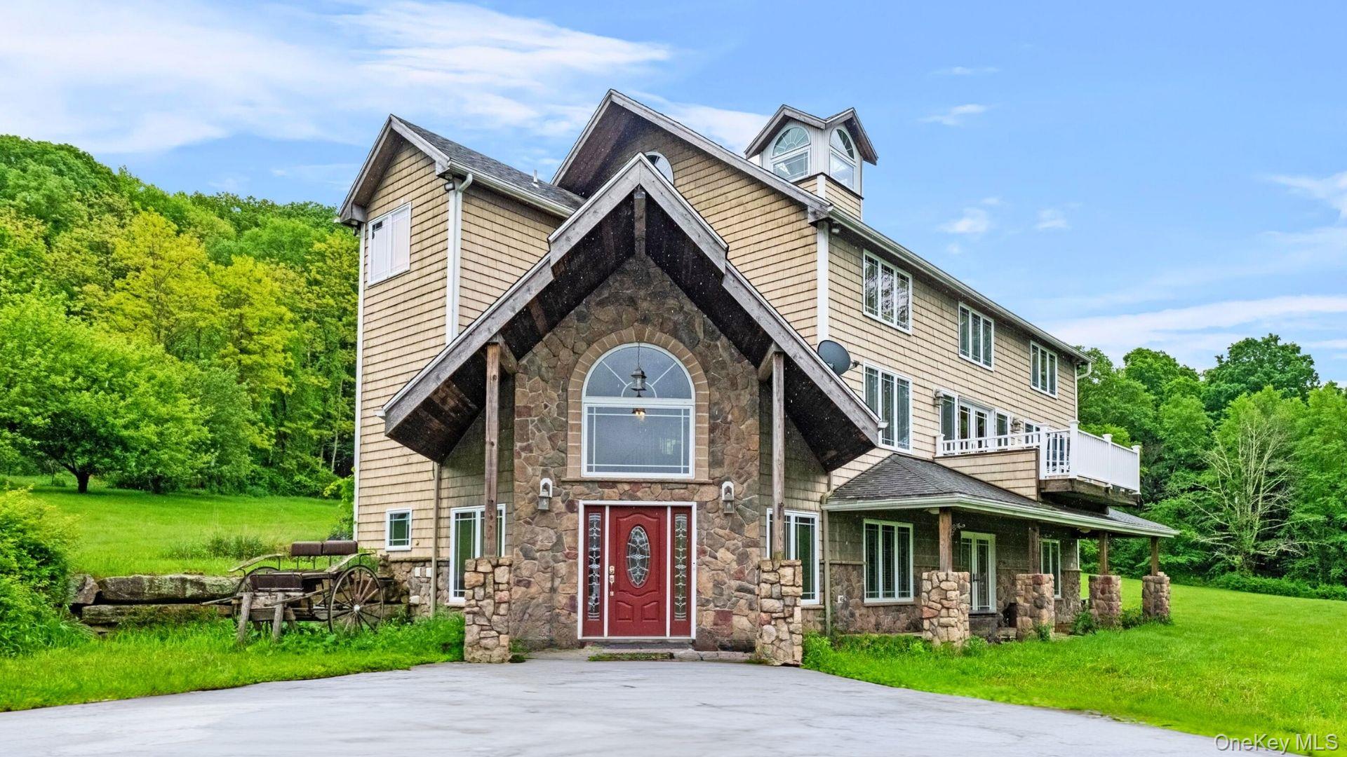 View of front of house featuring stone siding and a front lawn