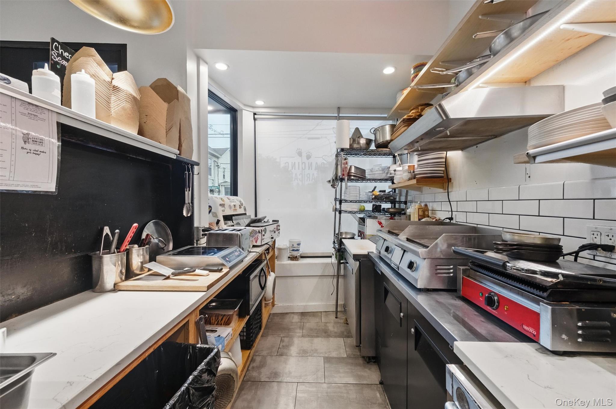 Kitchen featuring open shelves, tasteful backsplash, recessed lighting, and dark cabinetry