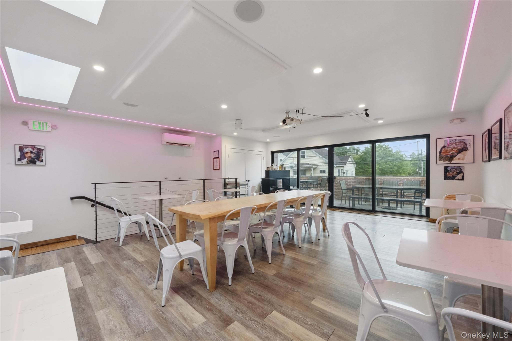 Dining area featuring an AC wall unit, a skylight, light wood-type flooring, and recessed lighting