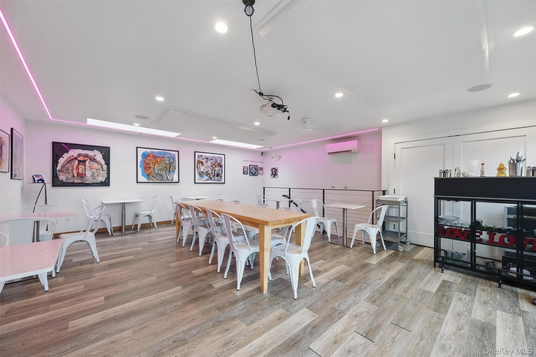 Dining area with an AC wall unit, wood finished floors, recessed lighting, and baseboards