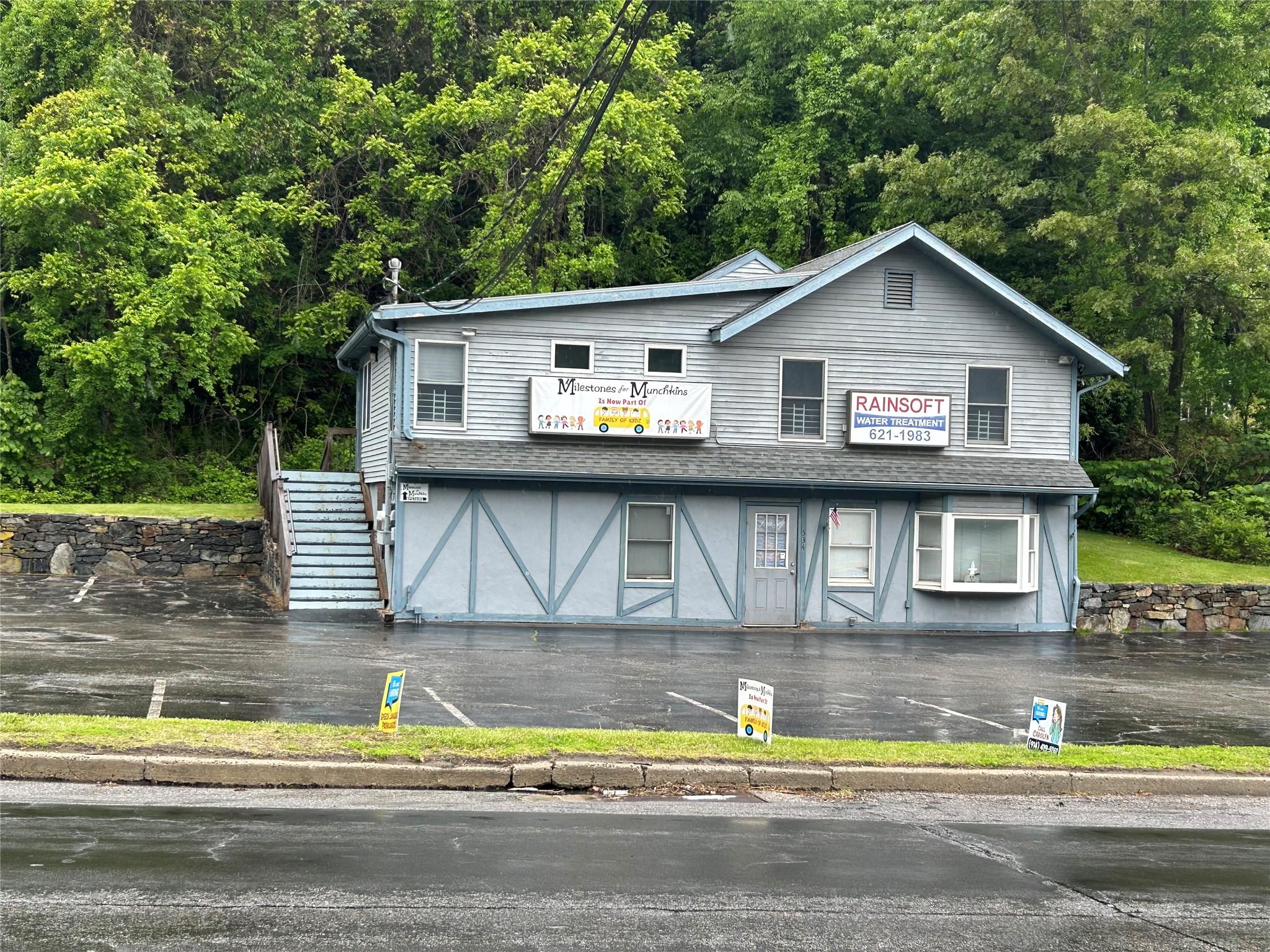 View of front of home featuring stairway and a wooded view