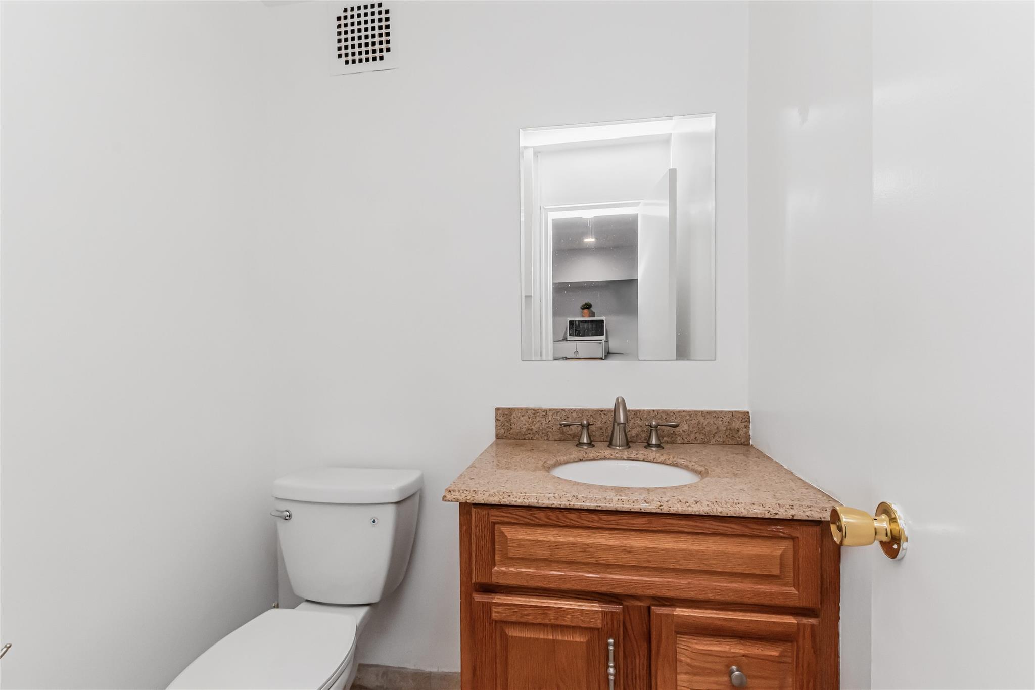 Half bath featuring toilet and vanity