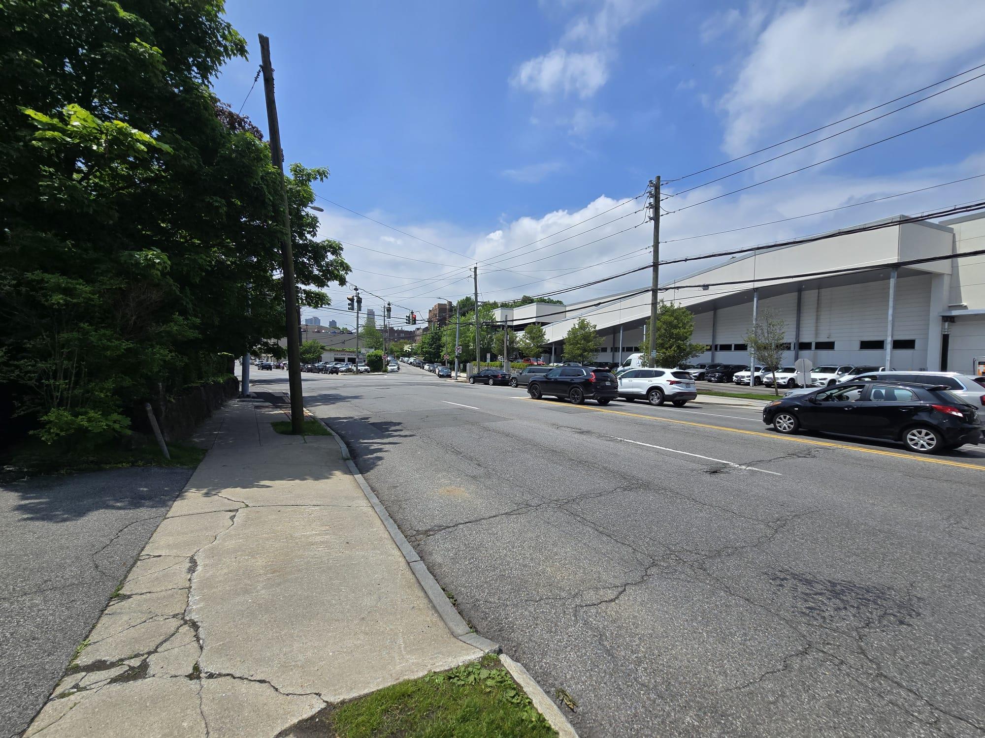 View of asphalt street featuring curbs and sidewalks