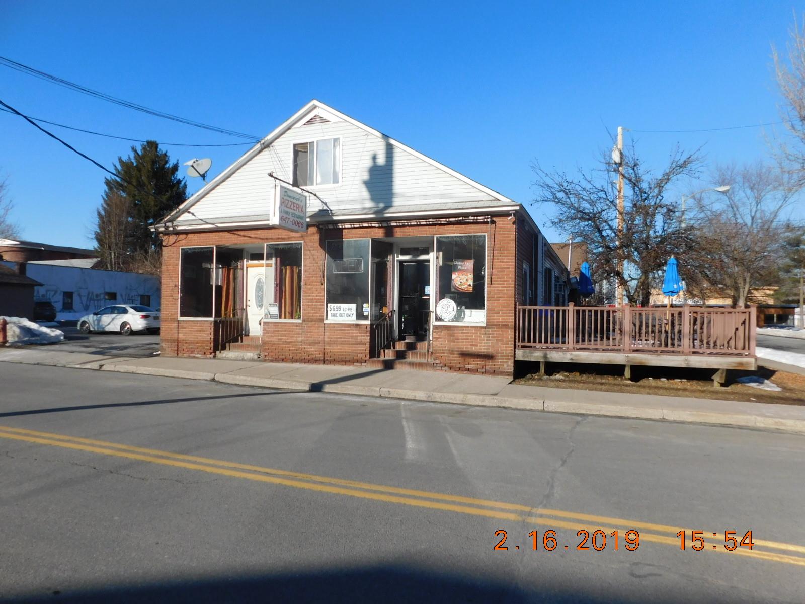 View of front of house featuring brick siding, entry steps, and a deck