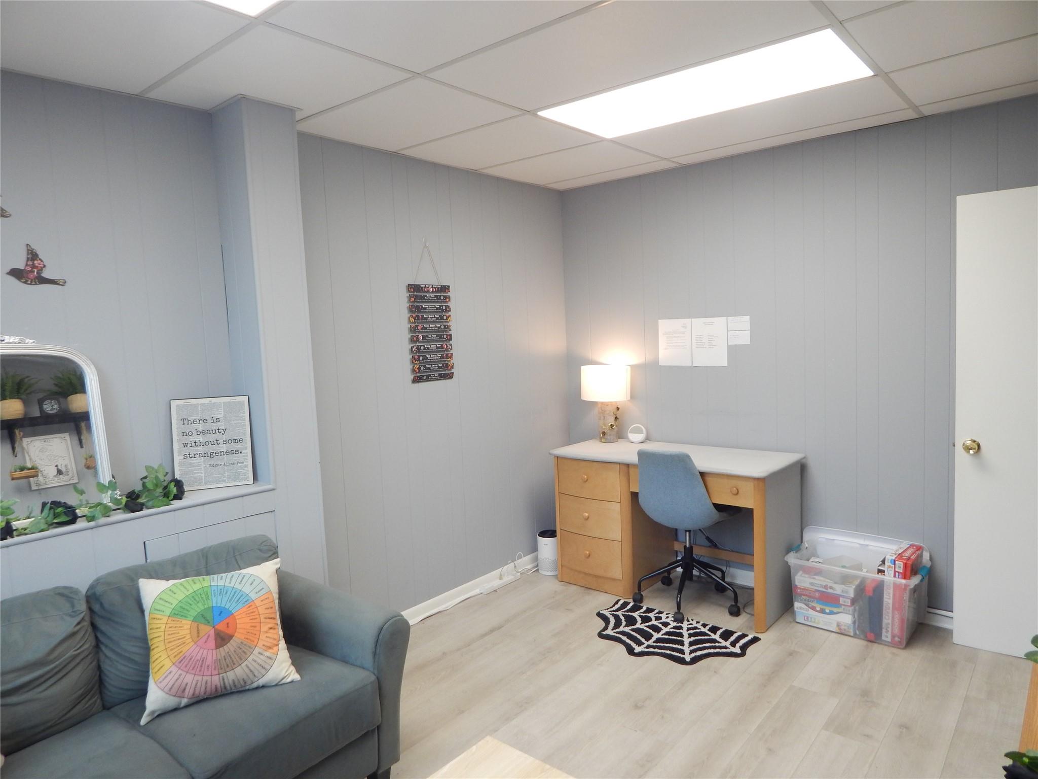 Office space with a drop ceiling, light wood-type flooring,