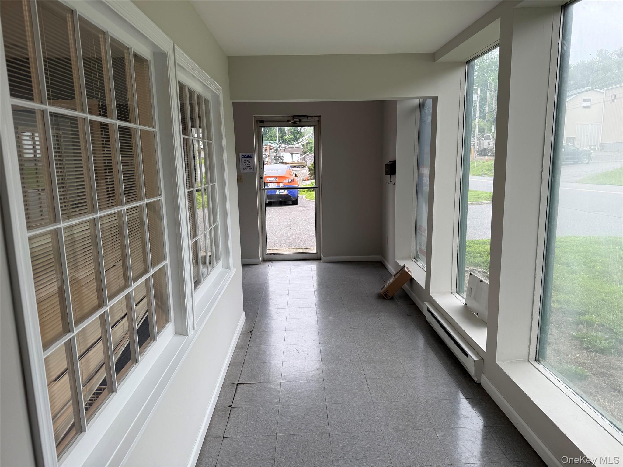 Unfurnished sunroom with baseboard heating