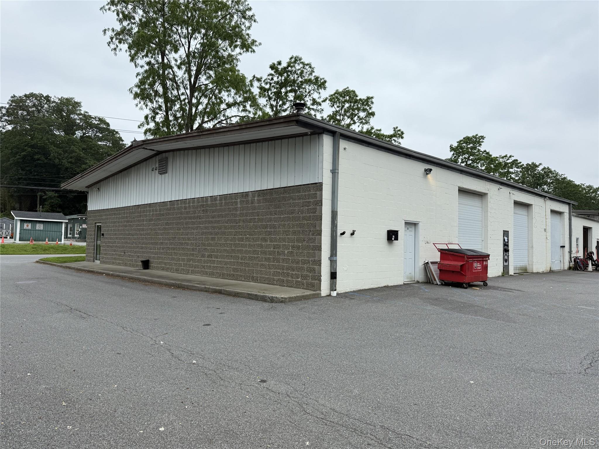 View of property exterior with concrete block siding and a garage