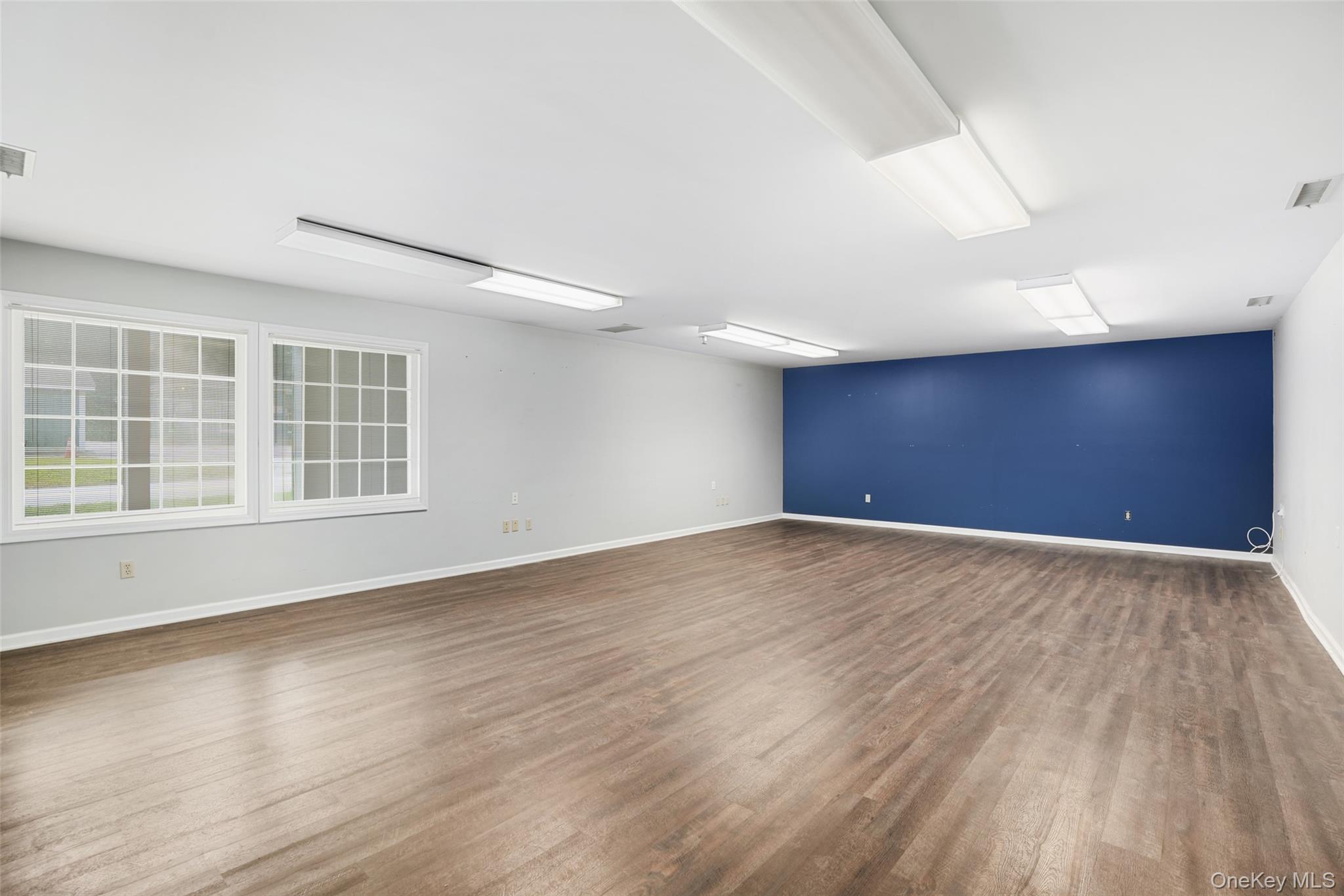 Empty room with dark wood-style floors and baseboards