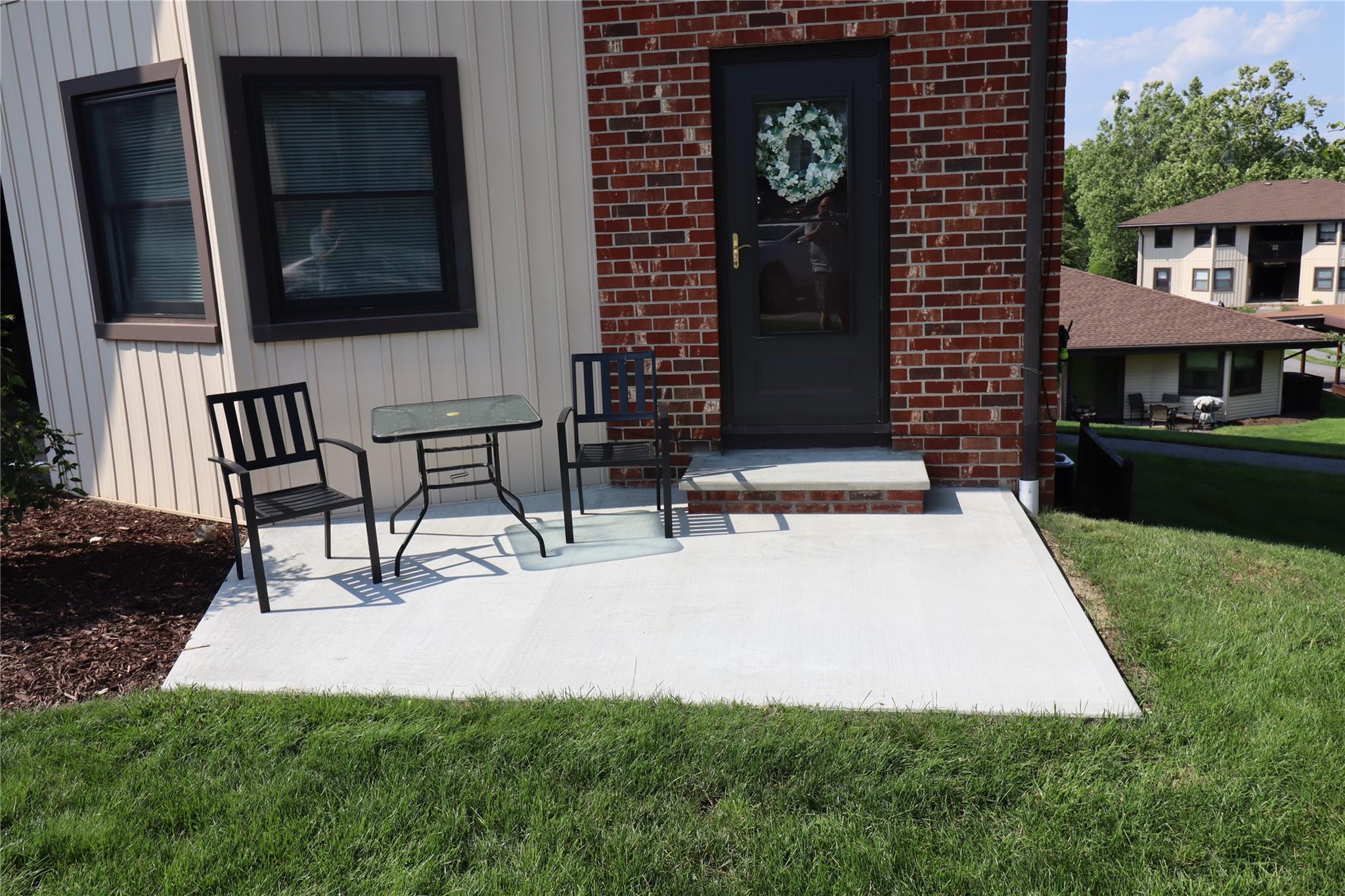 Doorway to property with brick siding and a lawn