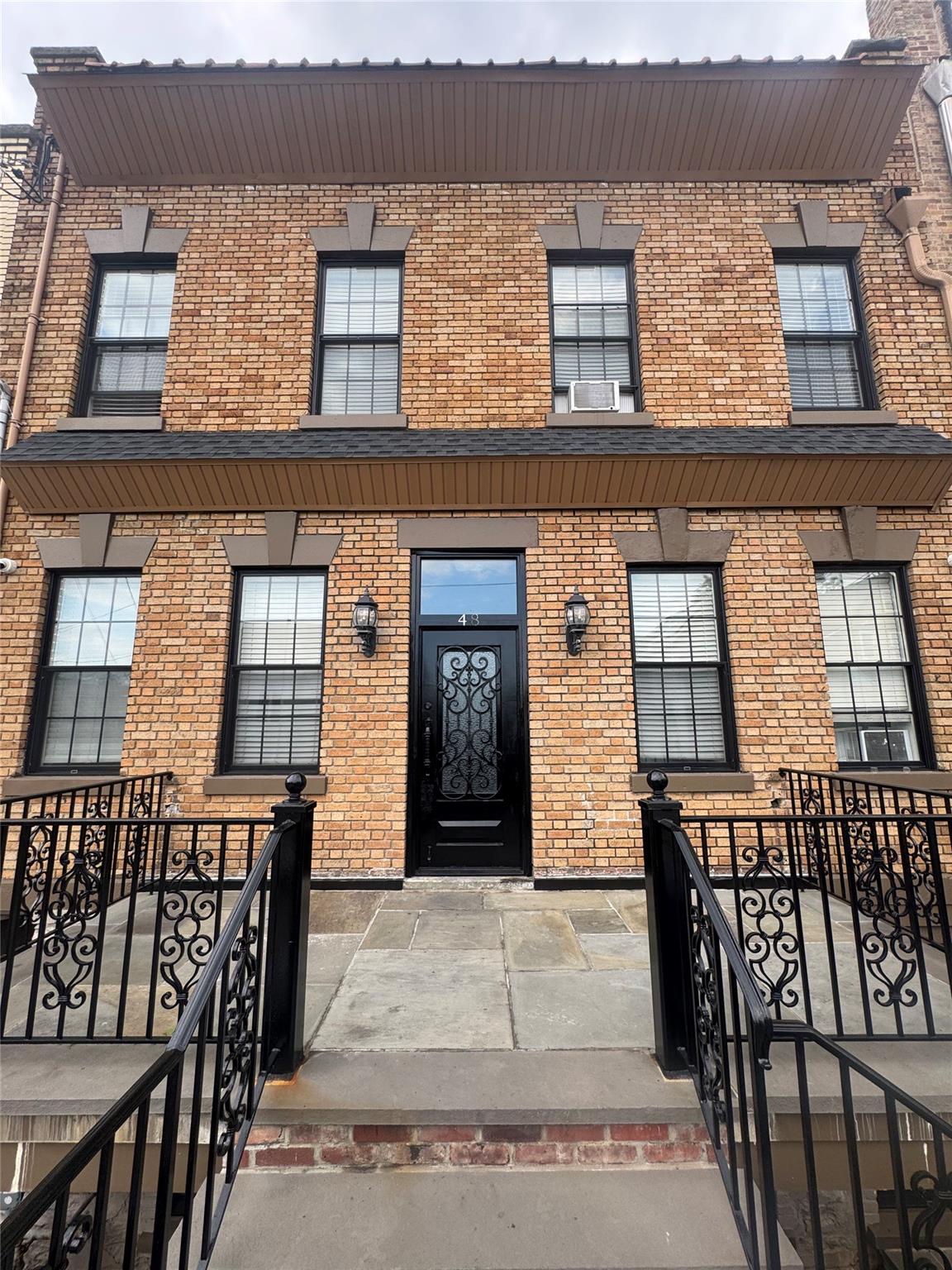 View of front of home with brick siding and cooling unit