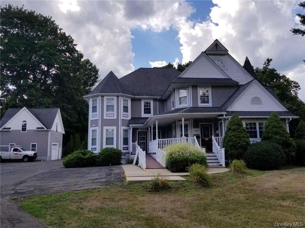Victorian home featuring a porch and a front lawn
