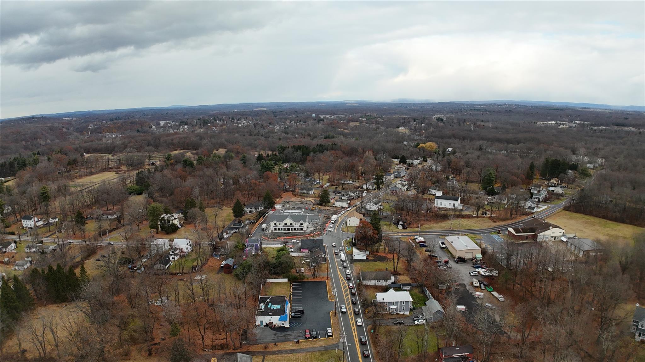 Aerial view of property and surrounding area with a heavily wooded area