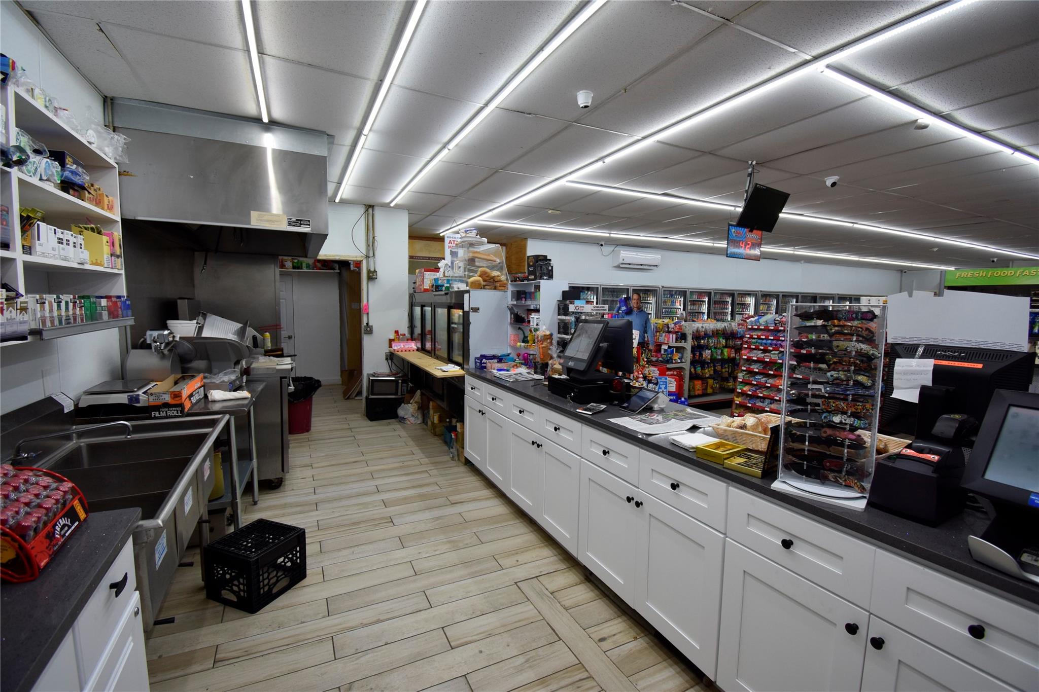 Kitchen with dark countertops, white cabinets, a wall mounted AC, and a paneled ceiling