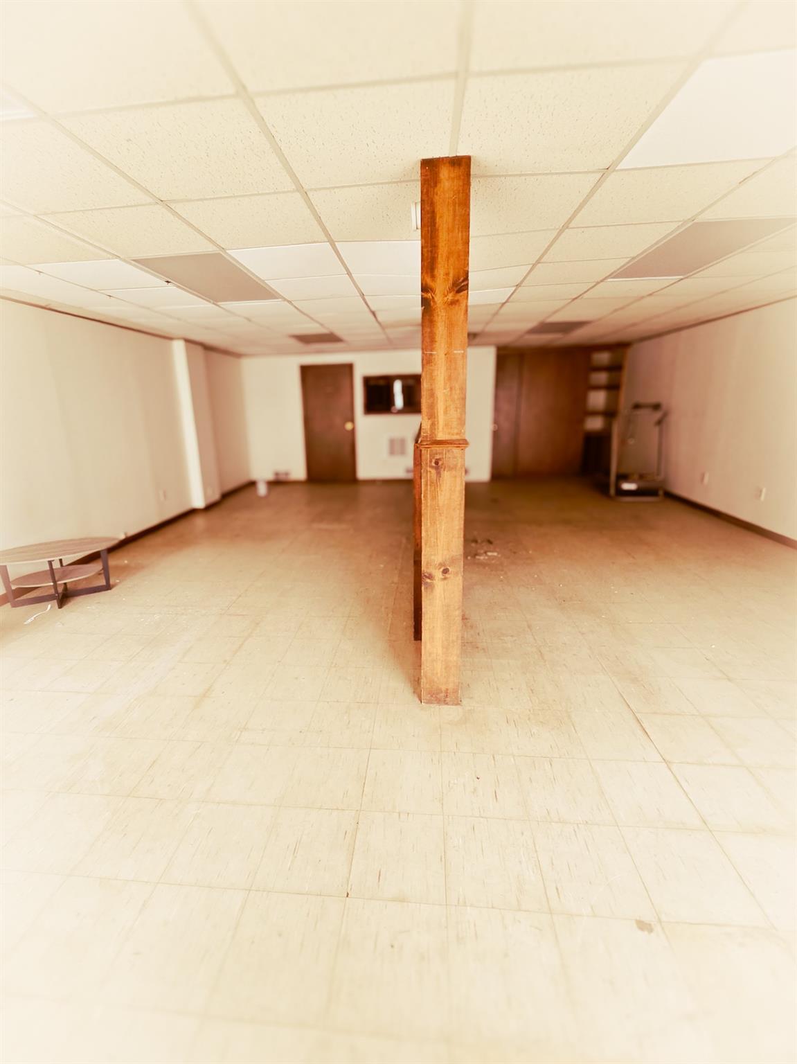 Studio area featuring a drop ceiling and light flooring
