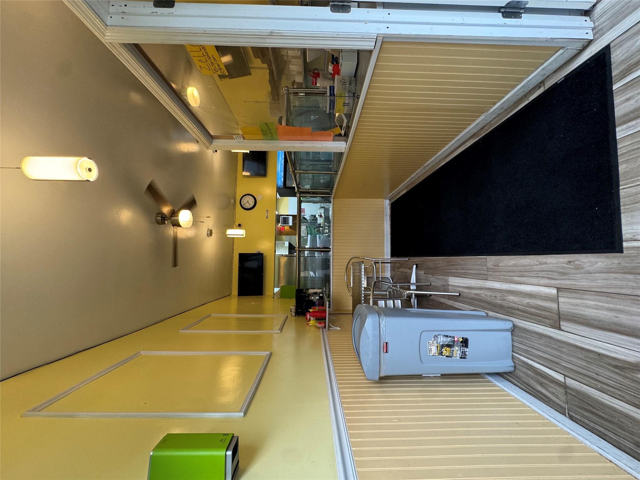 Kitchen featuring wood finished floors, ceiling fan, and wainscoting