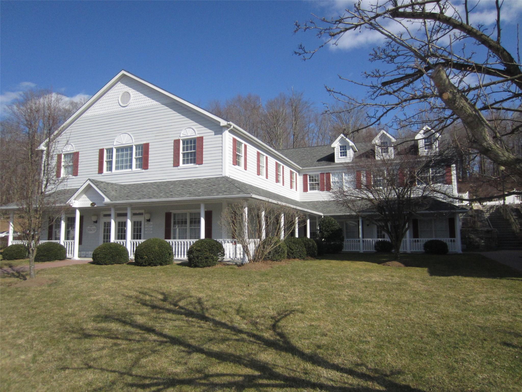 View of front of house featuring a porch, a front yard, and a shingled roof
