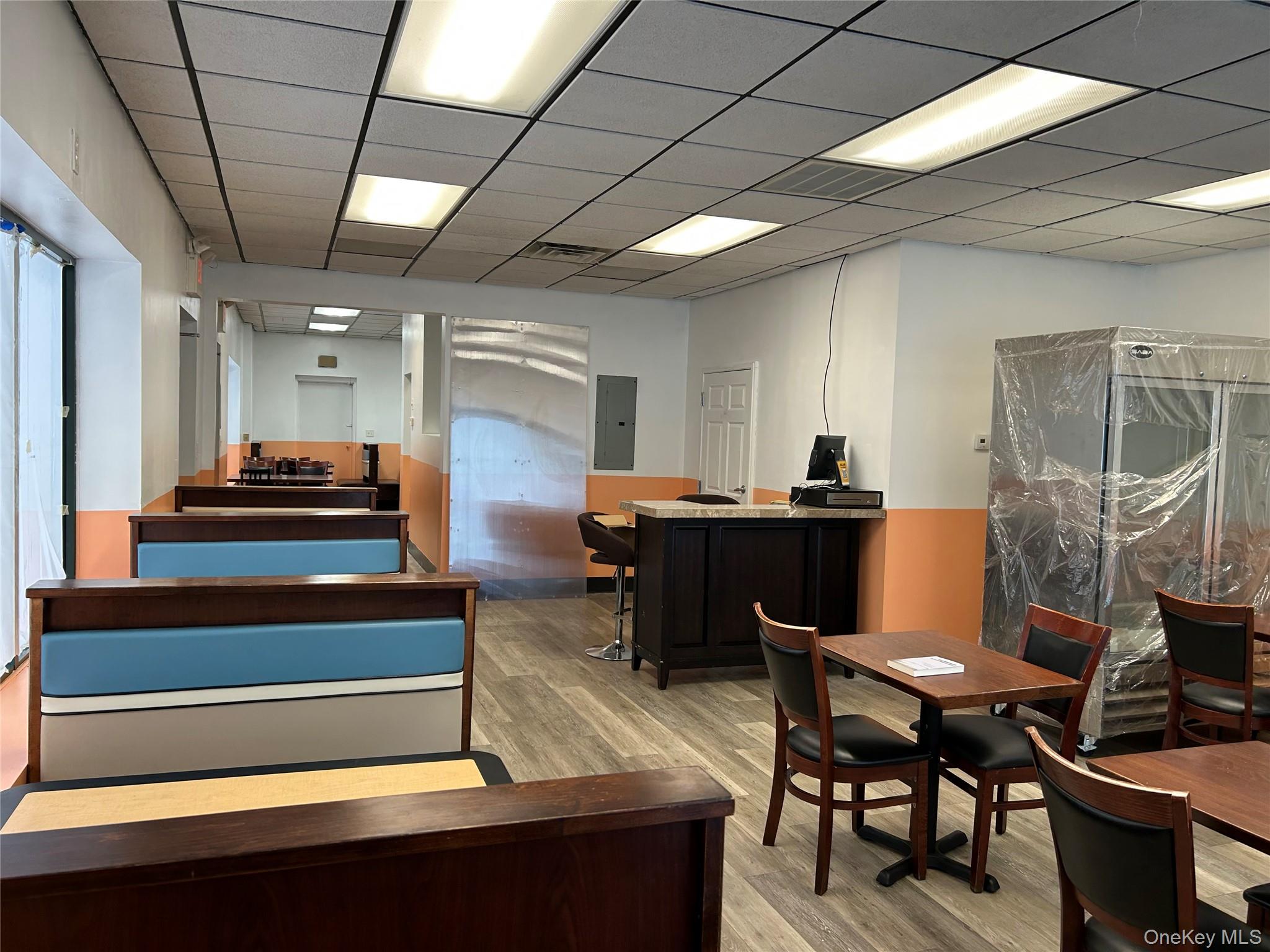 Office featuring electric panel and wood finished floors