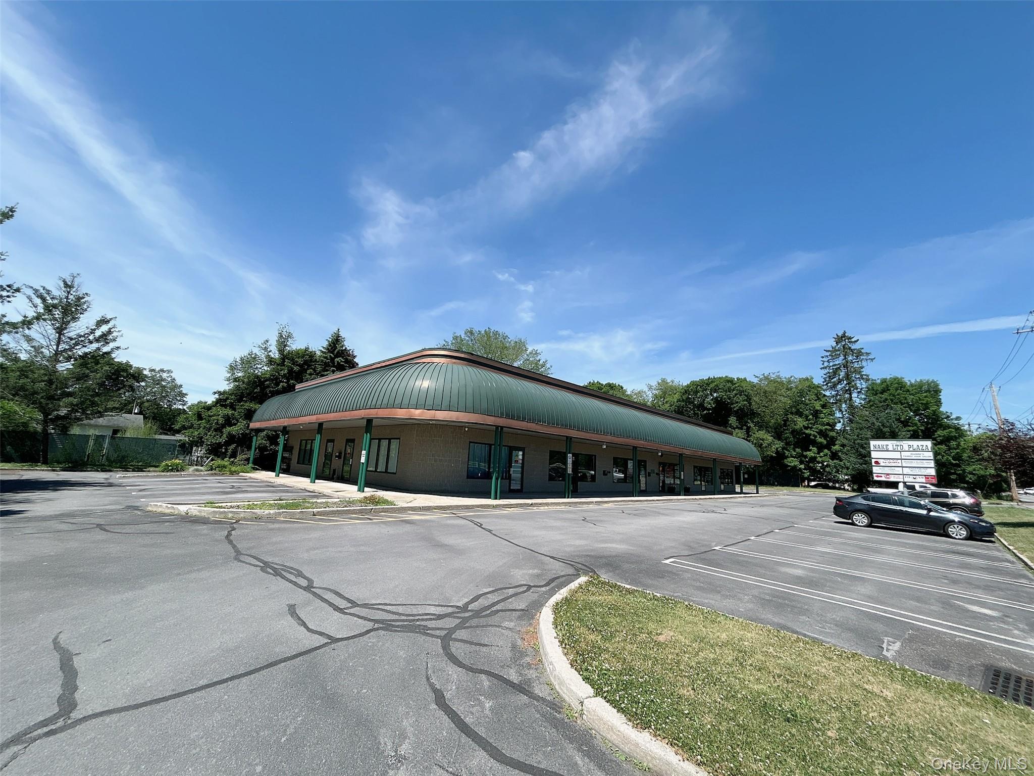 View of building exterior featuring uncovered parking