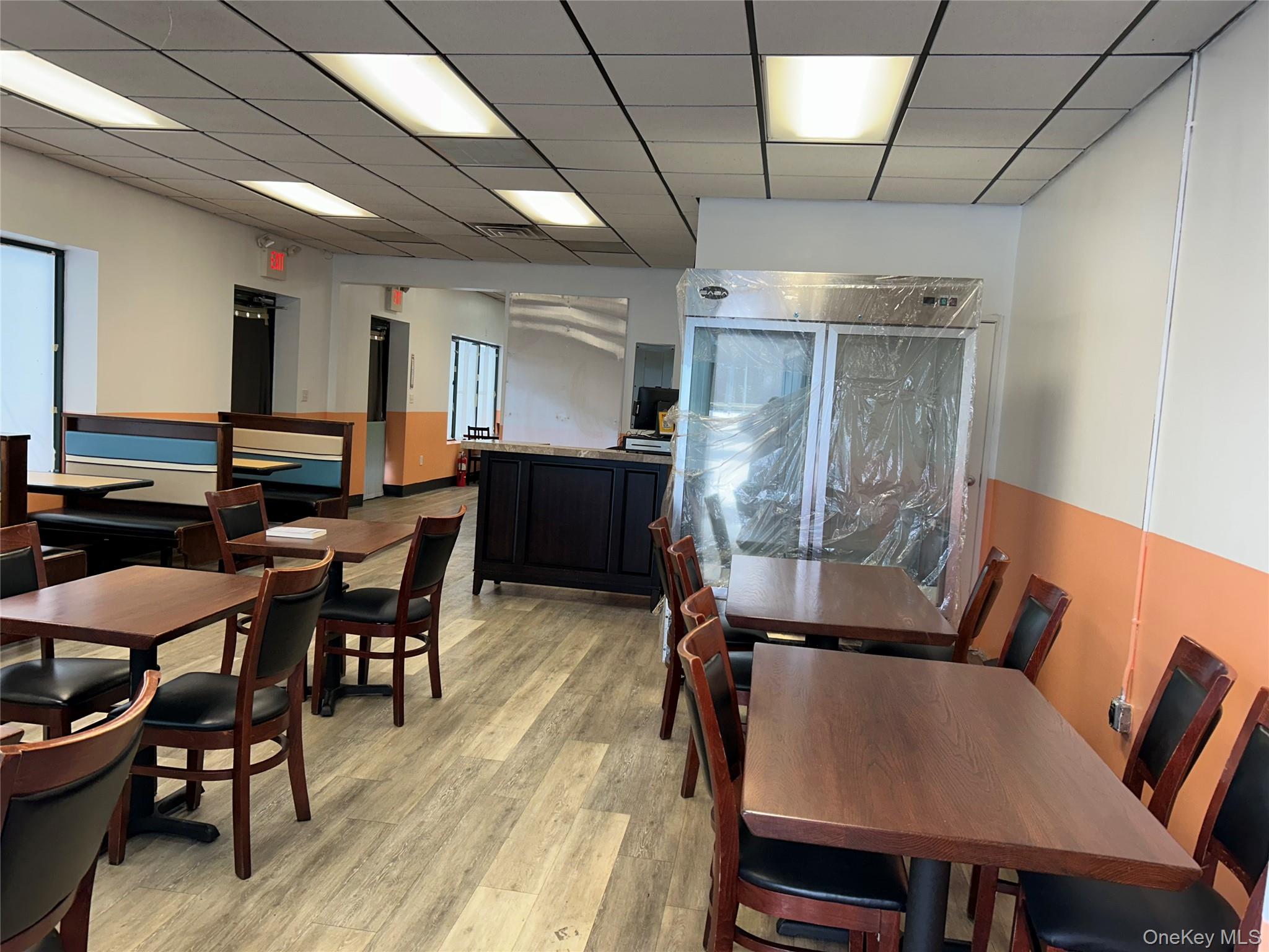 Dining area featuring light wood-style flooring and a drop ceiling