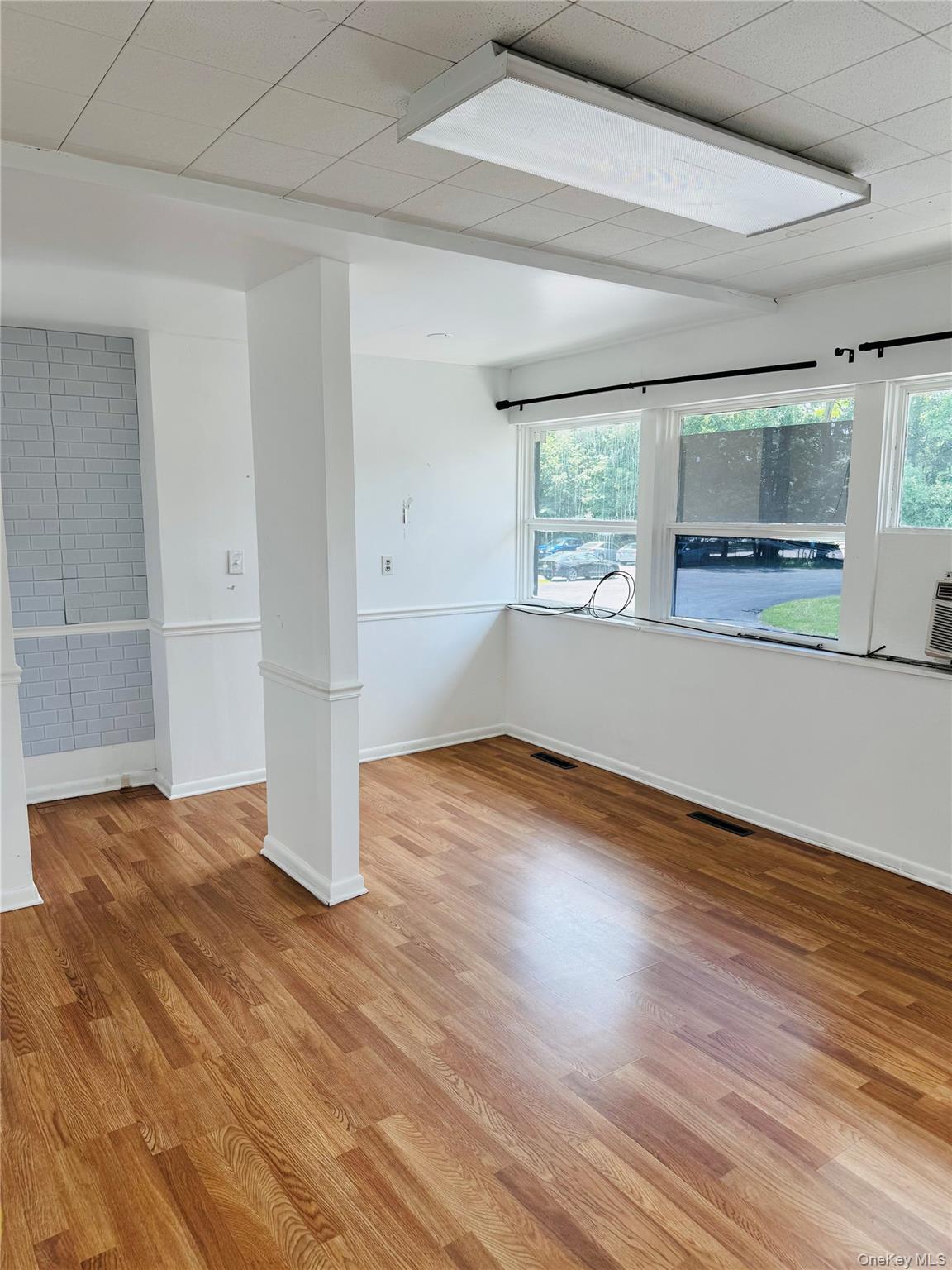 Office unit featuring light wood-style flooring and healthy amount of natural light.
