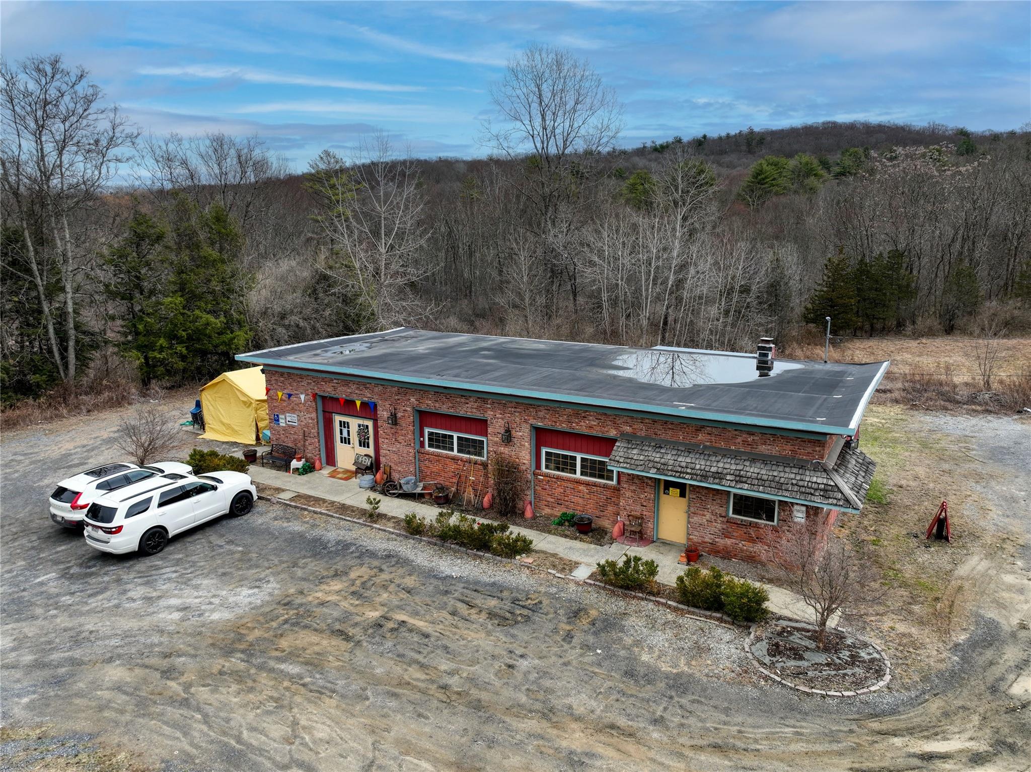 View of front facade featuring a wooded view and brick siding