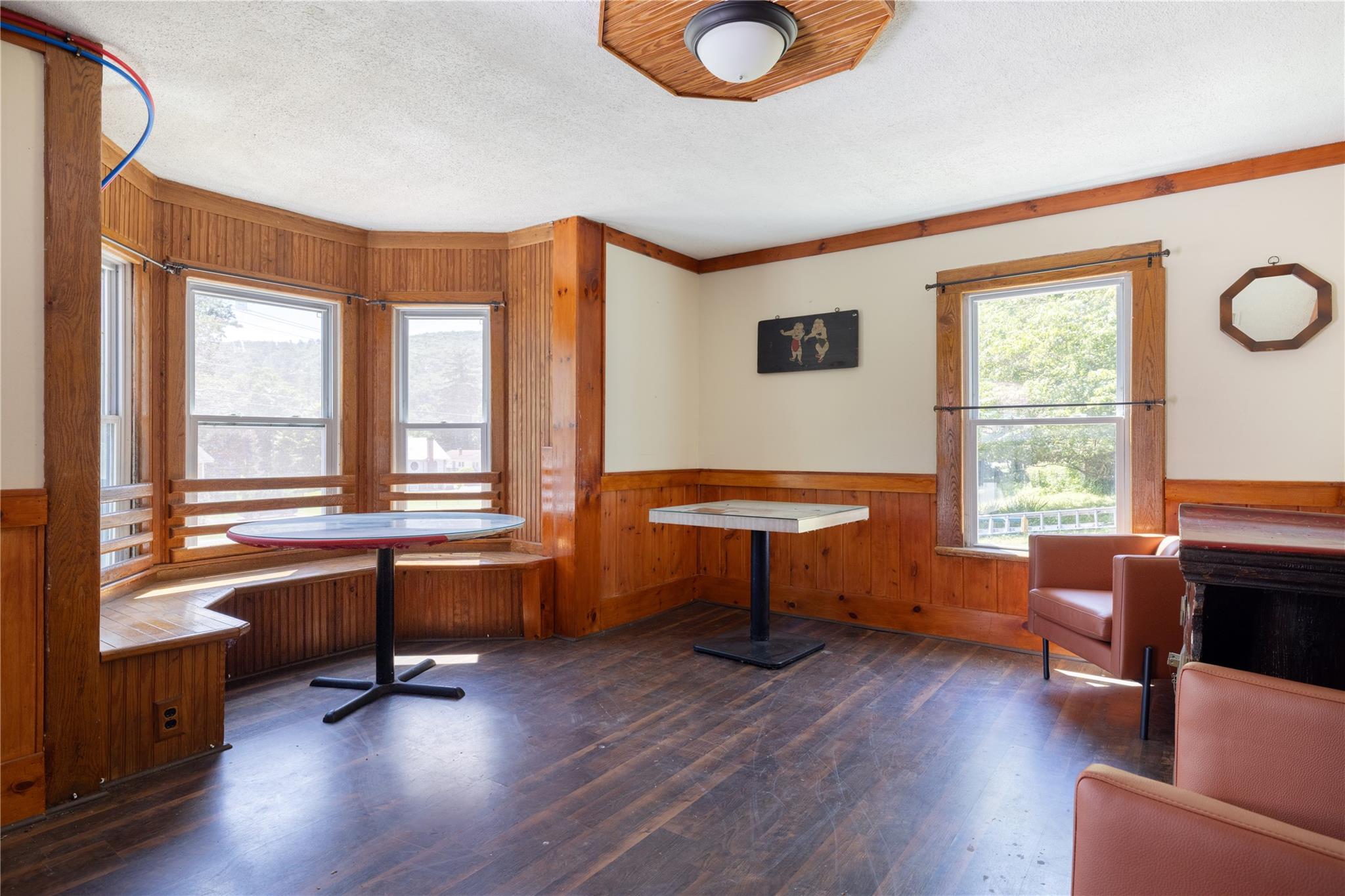 Office space with wooden walls, wood finished floors, a wainscoted wall, and a textured ceiling